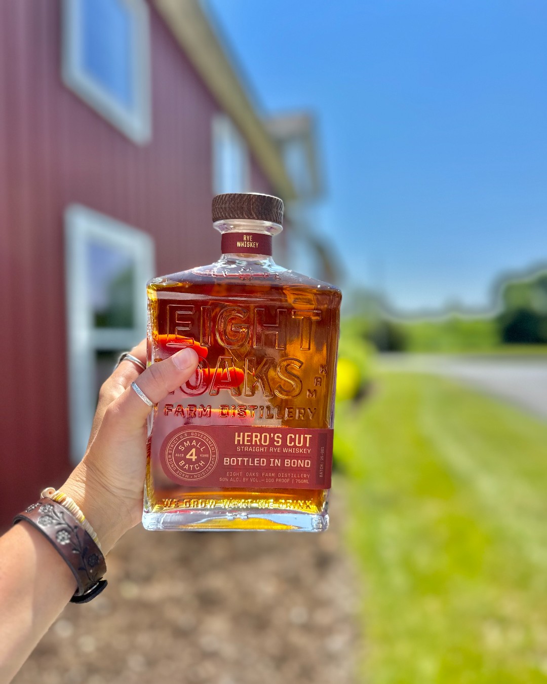Hero's Cut Bottled in Bond Rye Whiskey bottle on farm